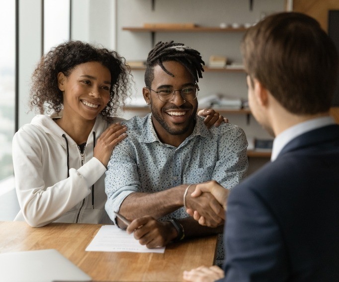 Man shaking hands with person sitting across table