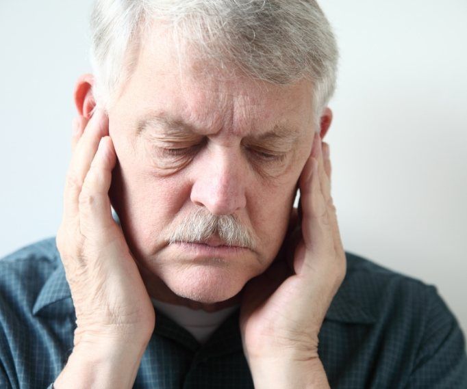 Man holding his temples in pain needing T M J treatment in Bayville